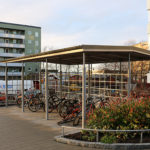 Sirius cykelhus med vÃ¤dertak och spaljÃ©, samt Goggle hjulhÃ¥llare. Svenska bostÃ¤der Rinkeby. Design Bernt FrÃ¶derberg